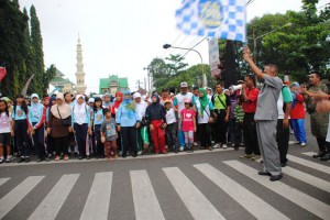 Bupati Purbalingga mengibarkan bendera start pada acara jalan sehat Mlaku Mlaku Karo Guru di alun-alun Purbalingga1